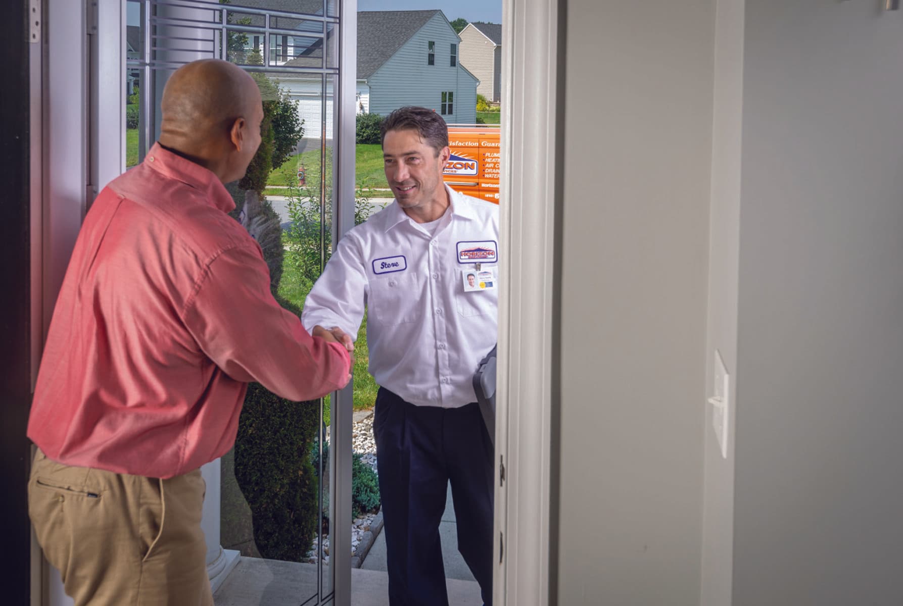 A smiling Horizon technician shaking the hand of a happy customer at their front door