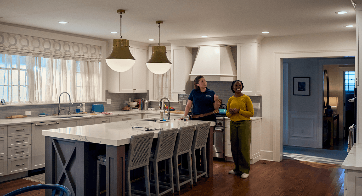 A homeowner and a Horizon technician talk in her dining room