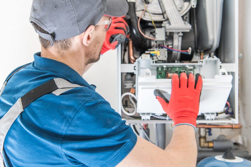 A Horizon technician inspecting the inner workings of a furnace