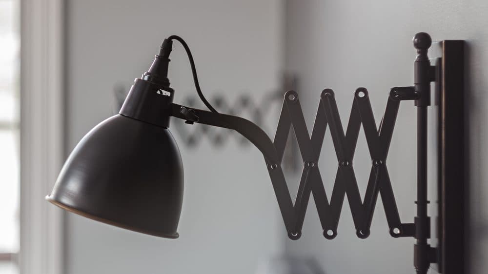 A whimsical swing arm wall sconce