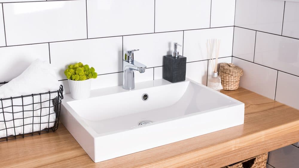 Rectangular, white bathroom sink with subway tiled walls