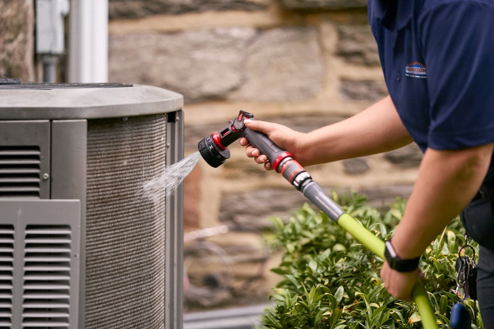 A Horizon Services technician maintaining a high-efficiency heat pump