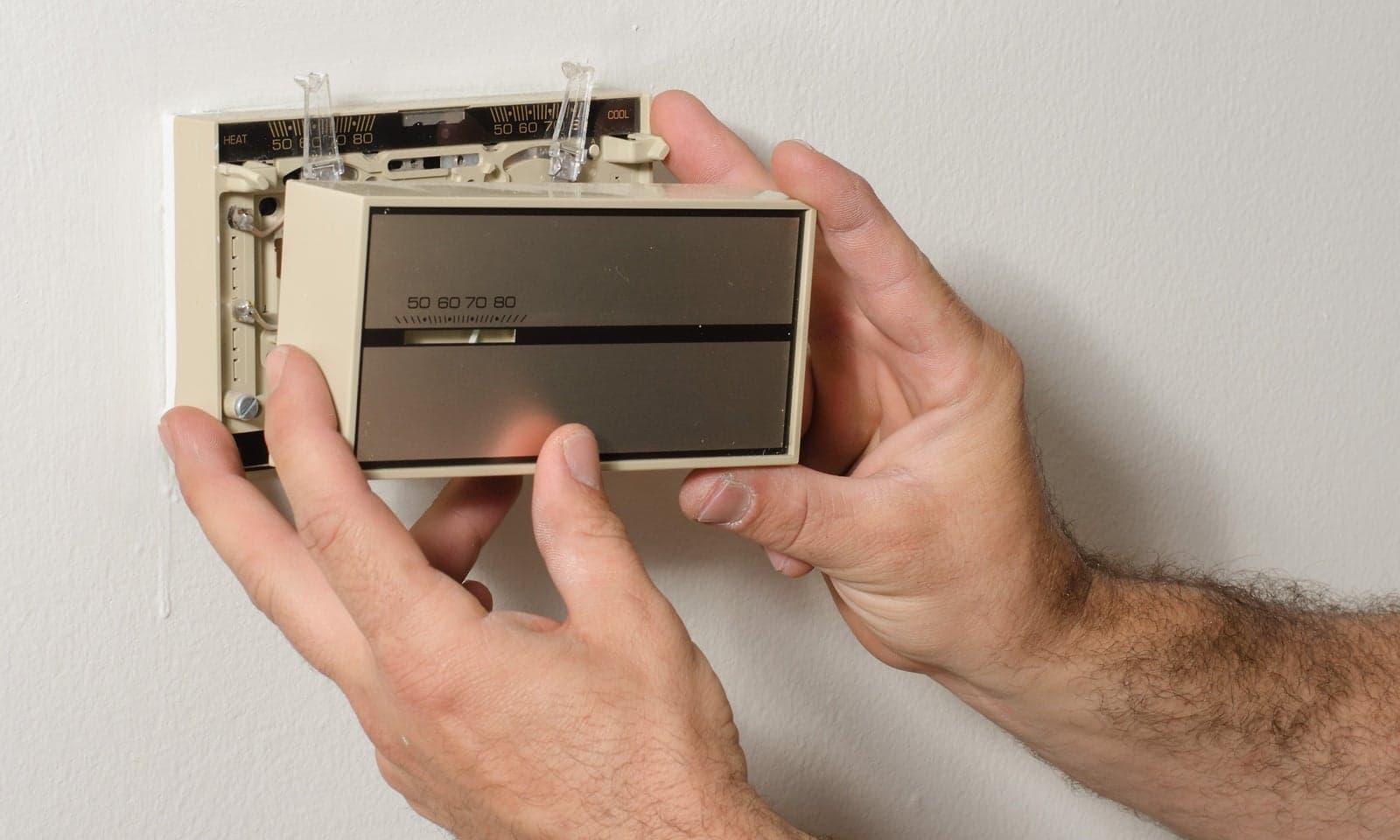 Removing an outdated thermostat to expose its wiring