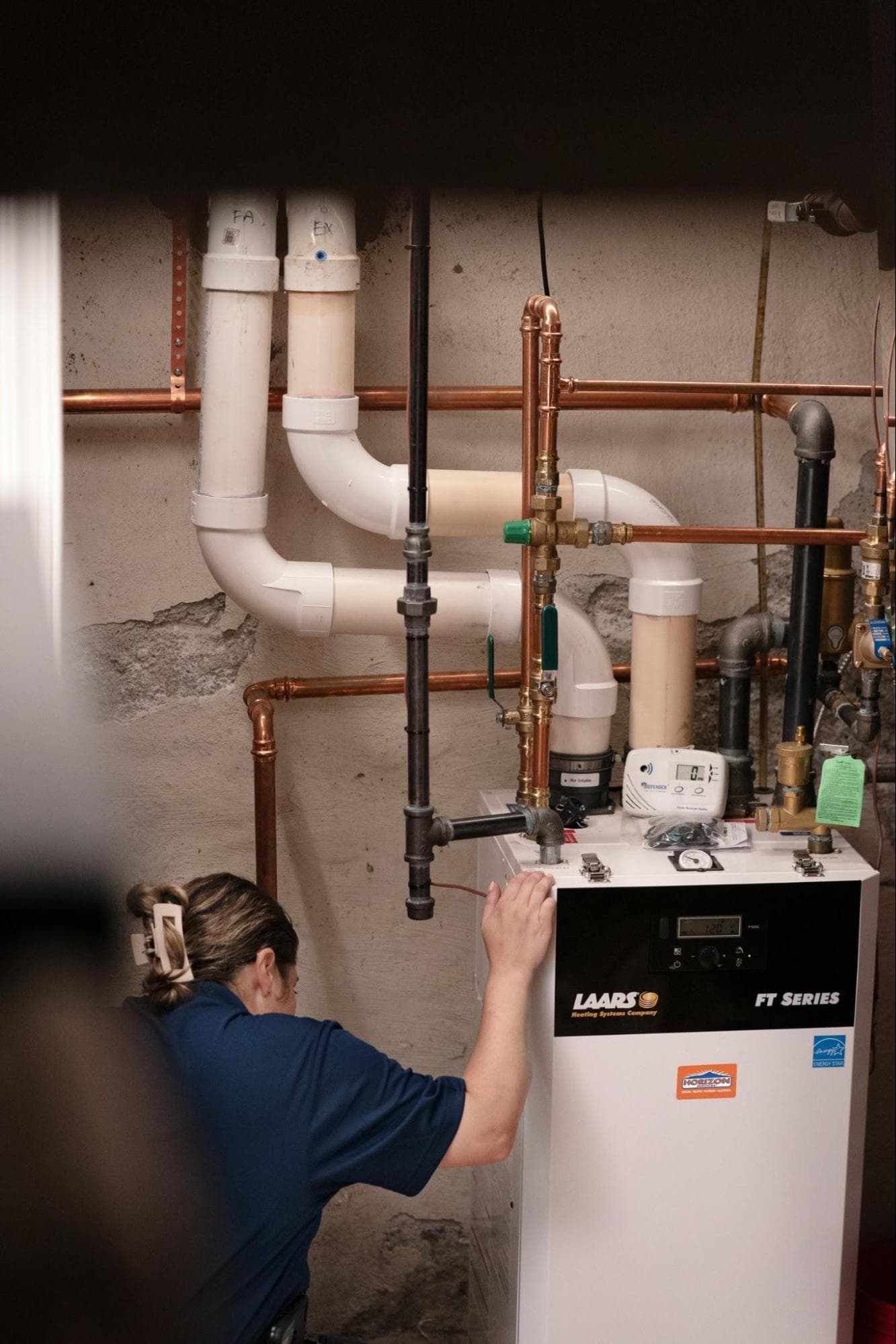 A Horizon Services technician servicing a wall-hung boiler