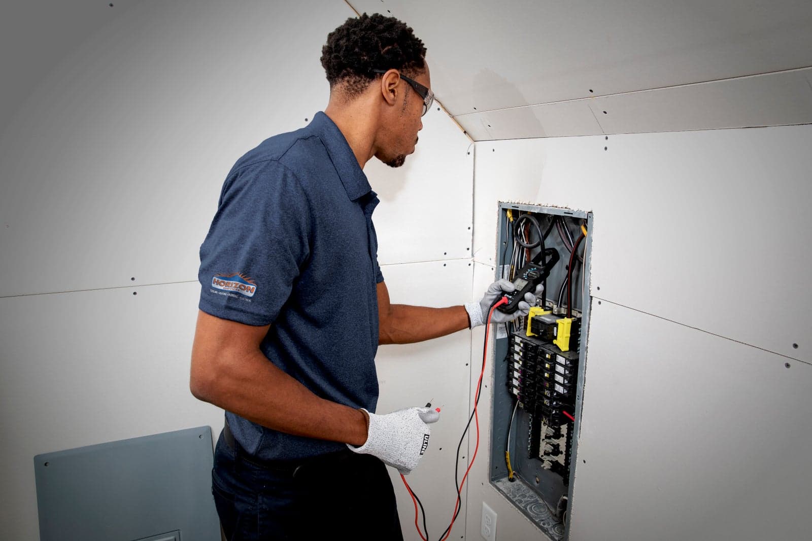 A Horizon Services electrician inspecting a home’s breaker panel