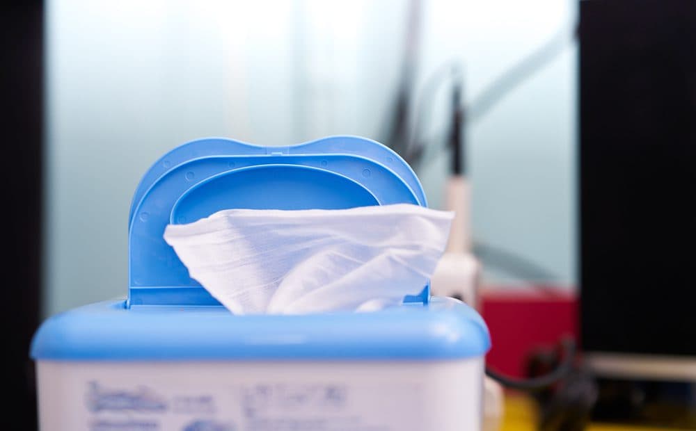 A single flushable wipe sitting out of the top of their packaging
